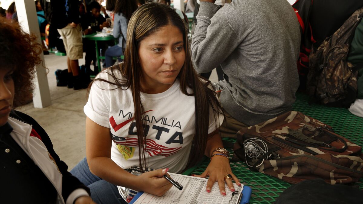 At Liberty High School in Kissimmee, Fla., Jeamy Ramirez, of MiFamiliaVota, registers potential voters during the school's lunch break.