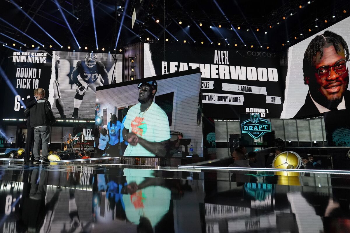An image of Alabama tackle Alex Leatherwood is displayed on stage after he was chosen by the Las Vegas Raiders with the 17th pick during the first round of the NFL football draft, Thursday, April 29, 2021, in Cleveland. (AP Photo/Tony Dejak)