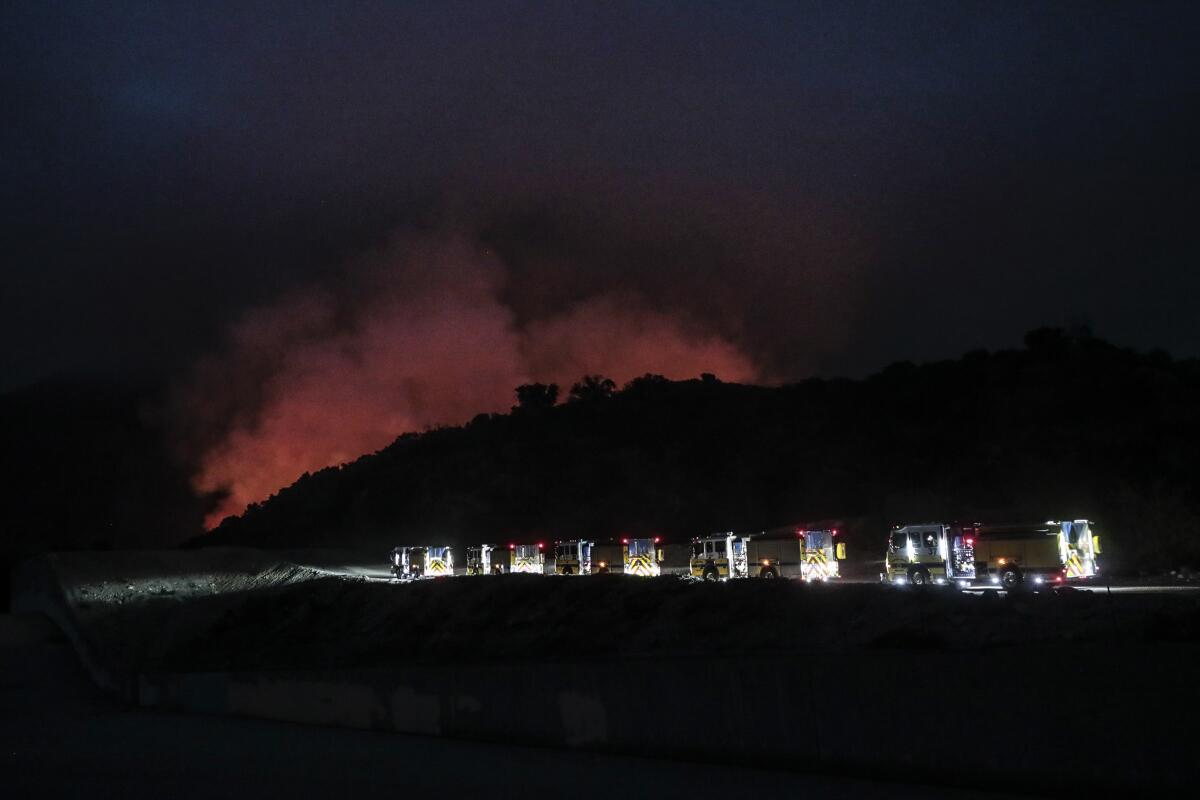 A line of fire engines head to the flaming Santa Anita Canyon as the Bobcat fire burns near Arcadia.