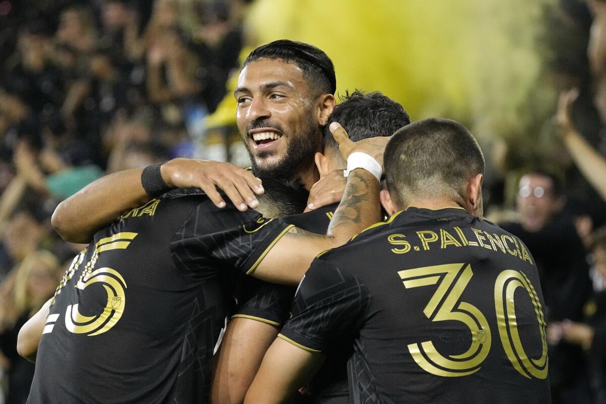 LAFC's Denis Bouanga, top, celebrates with teammates during a match against Minnesota on Oct. 4.
