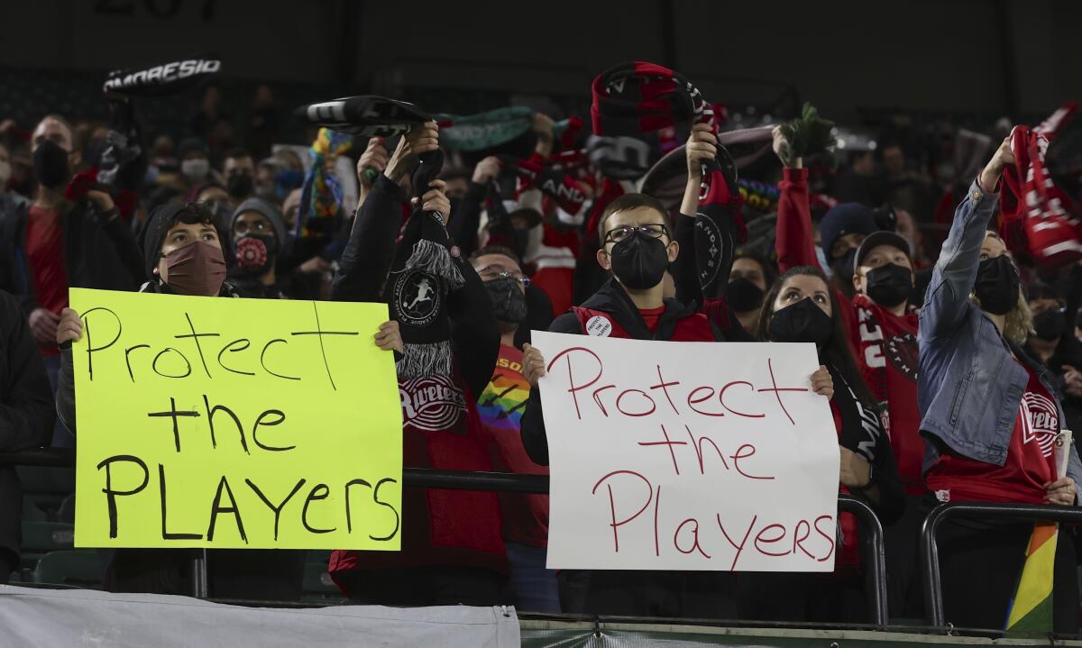 aficionados del Portland Thorns sostienen letros en el encuentro del equipo ante el Houston Dash 