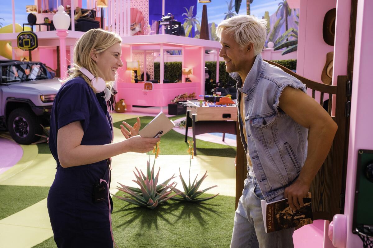 Greta Gerwig smiles and chats with Ryan Gosling while on the set of "Barbie."