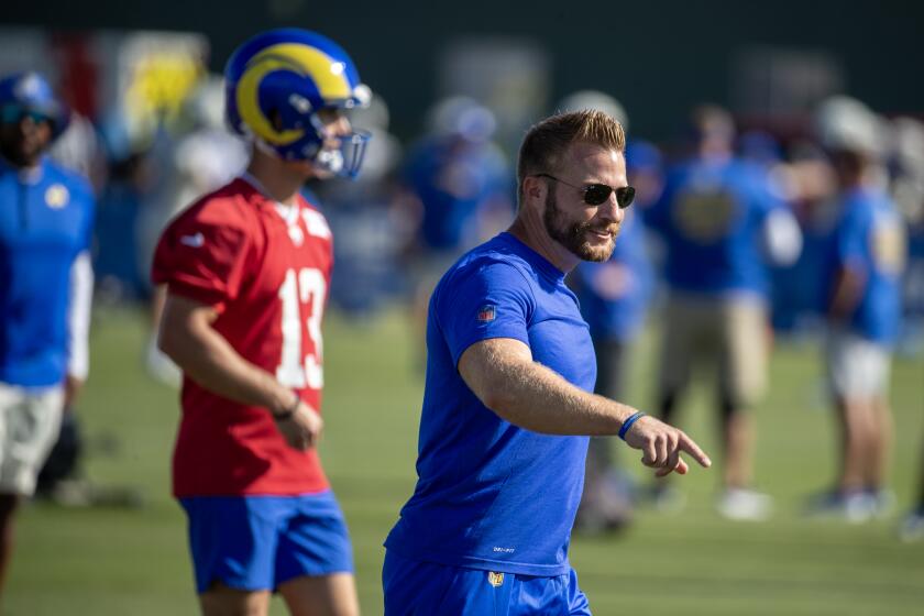 Rams coach Sean McVay walks ahead of quarterback Stetson Bennett during training camp.