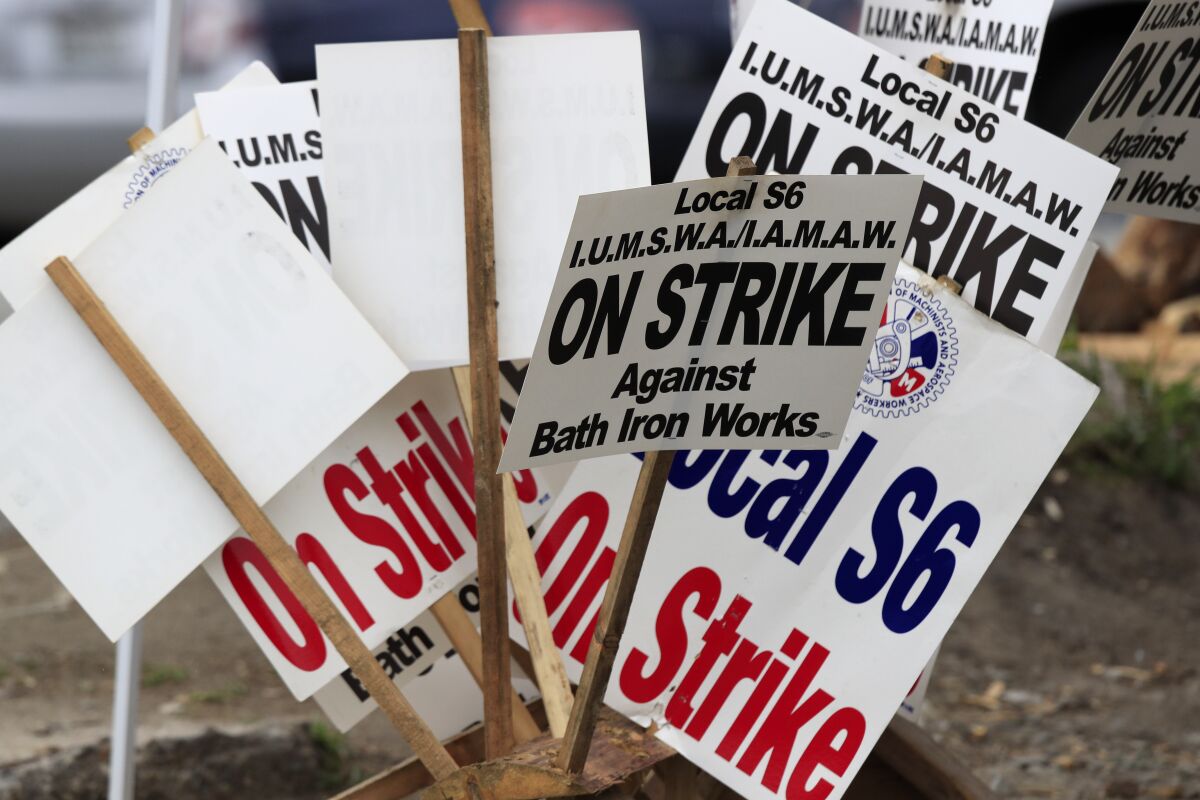 Striker's signs are gathered near Bath Iron Works, Wednesday, July 22, 2020, in Bath, Maine. The International Association of Machinists and Aerospace Workers Local S6 is in its fifth week of the strike over a new contract. The shipbuilder and union remain at odds over issues of seniority and subcontractors. (AP Photo/Robert F. Bukaty)