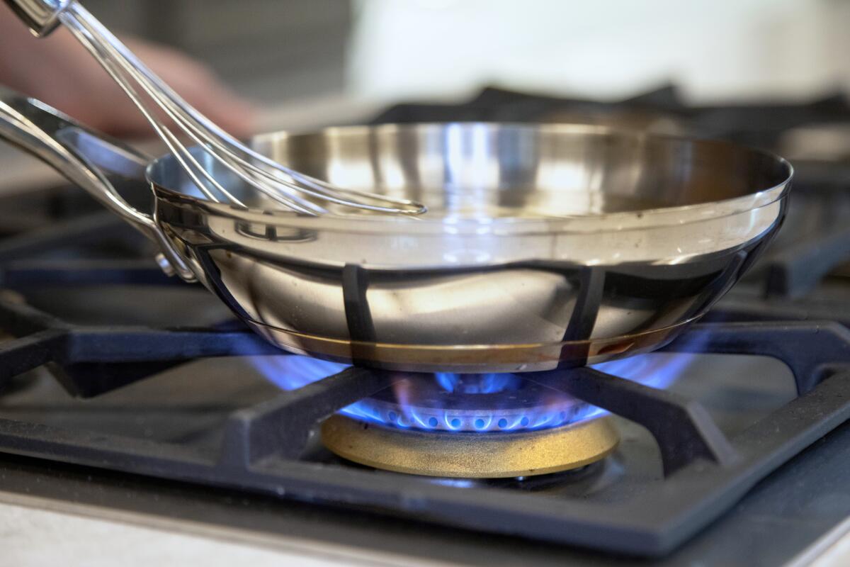 A pan heated over a gas stove top burner.