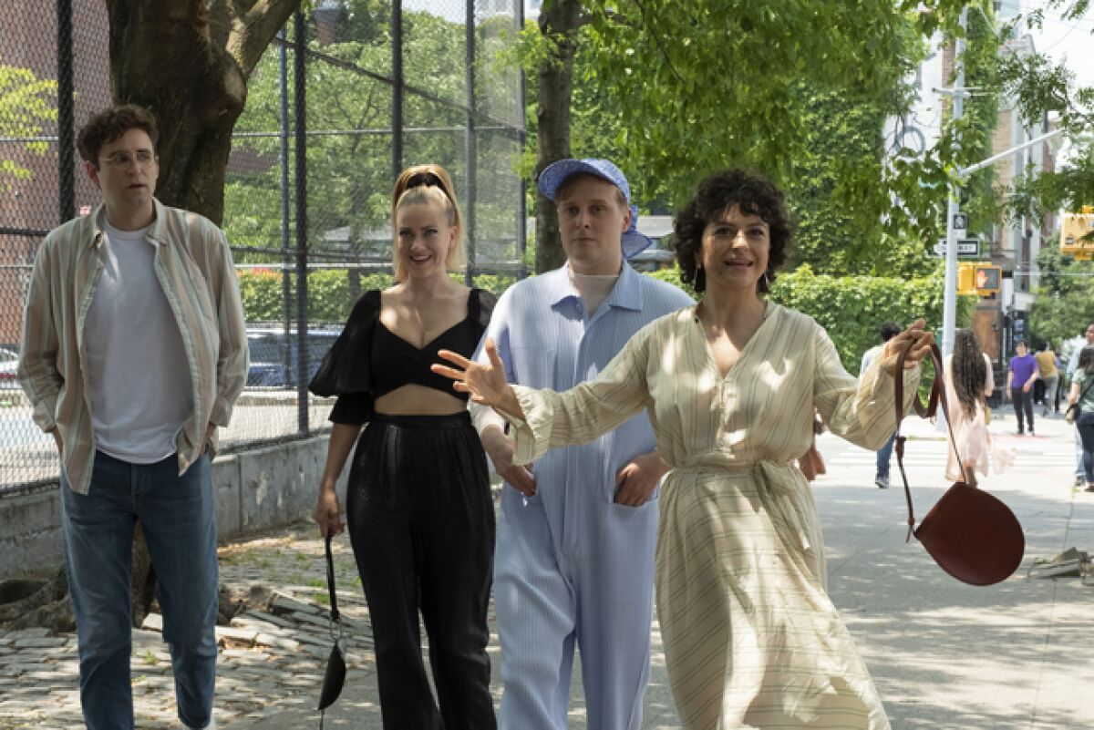 Four friends walk down a New York sidewalk