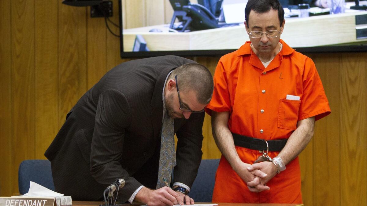 Larry Nassar, with attorney Matthew Newberg, is serving decades in prison for molesting girls and women and for possessing child pornography.