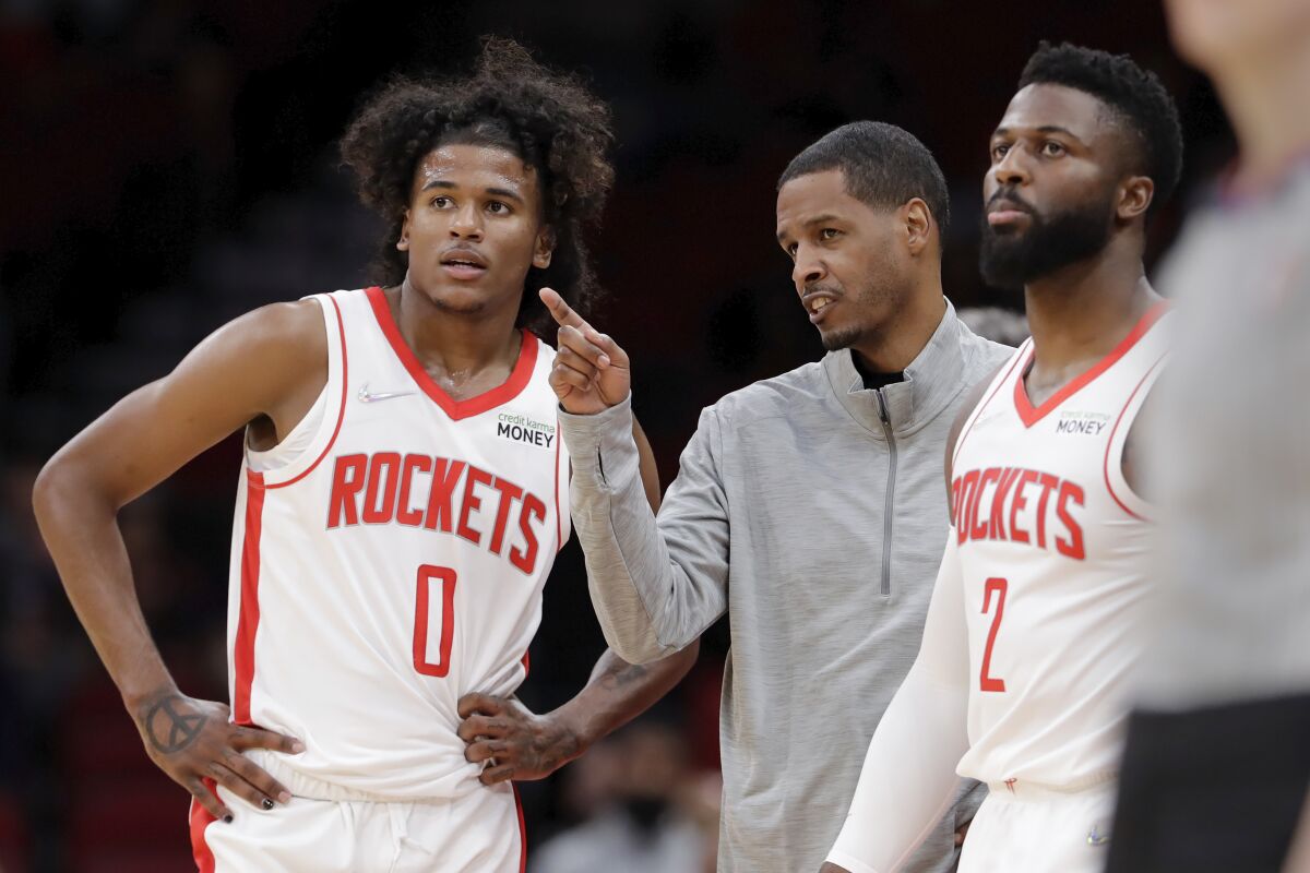Houston Rockets head coach Stephen Silas, center, talks with guard Jalen Green (0) and forward David Nwaba (2) during a time out during the first half of an NBA basketball game against the Washington Wizards Tuesday, Oct. 5, 2021, in Houston. (AP Photo/Michael Wyke)