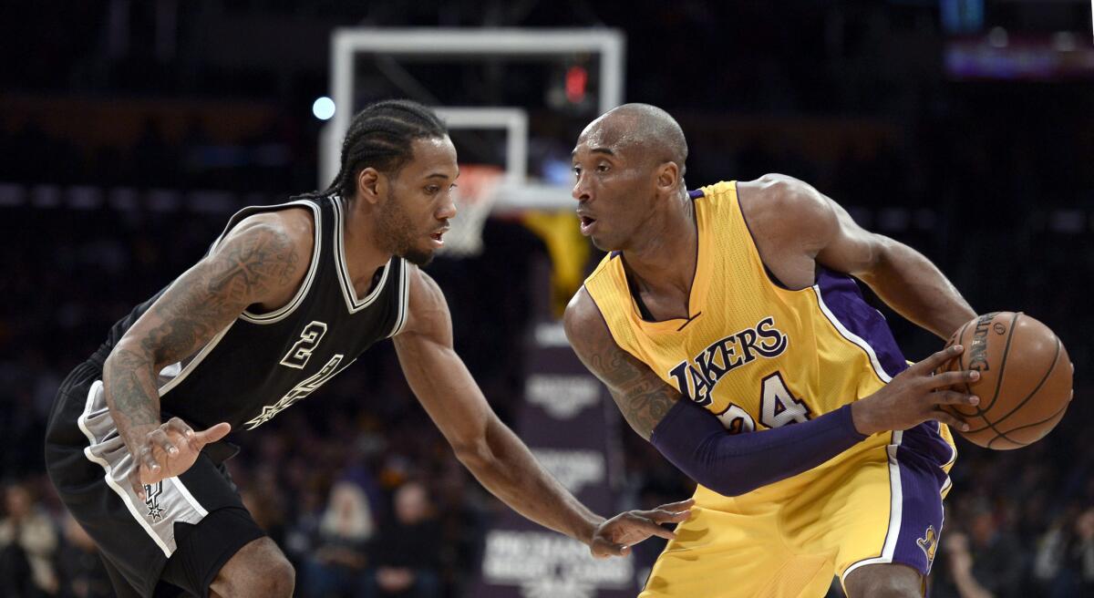 Kobe Bryant, right, controls the ball in front of Kawhi Leonard during a game between the Lakers and San Antonio Spurs in January 2016.