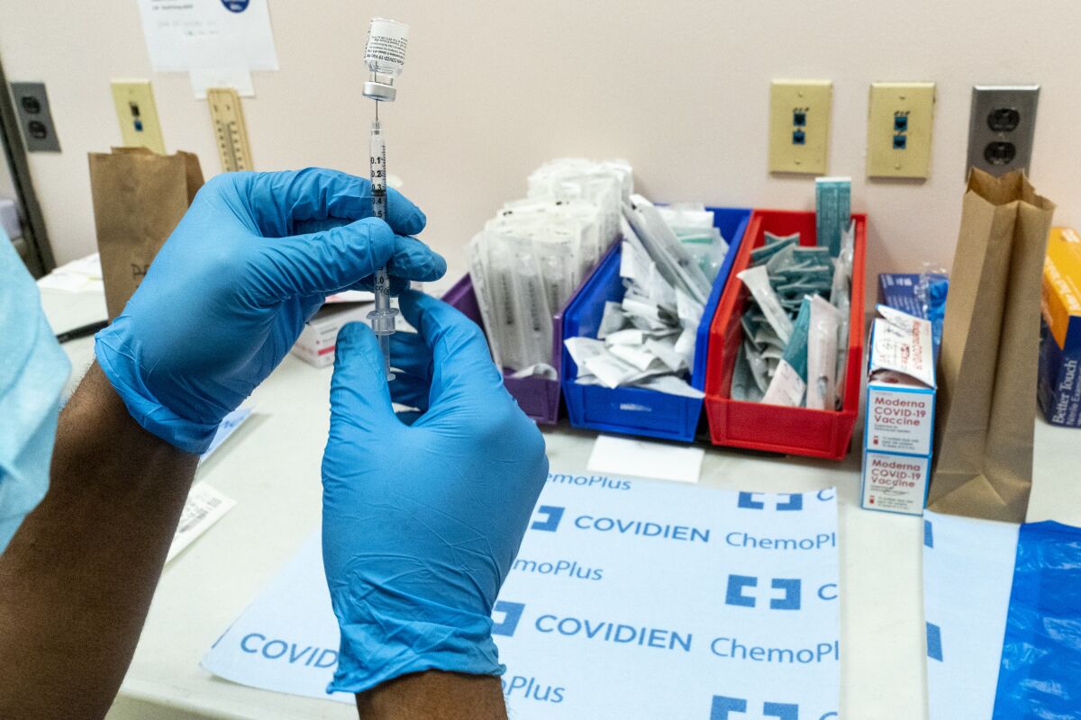 A pharmacist prepares a syringe with the Pfizer-BioNTech COVID-19 vaccine