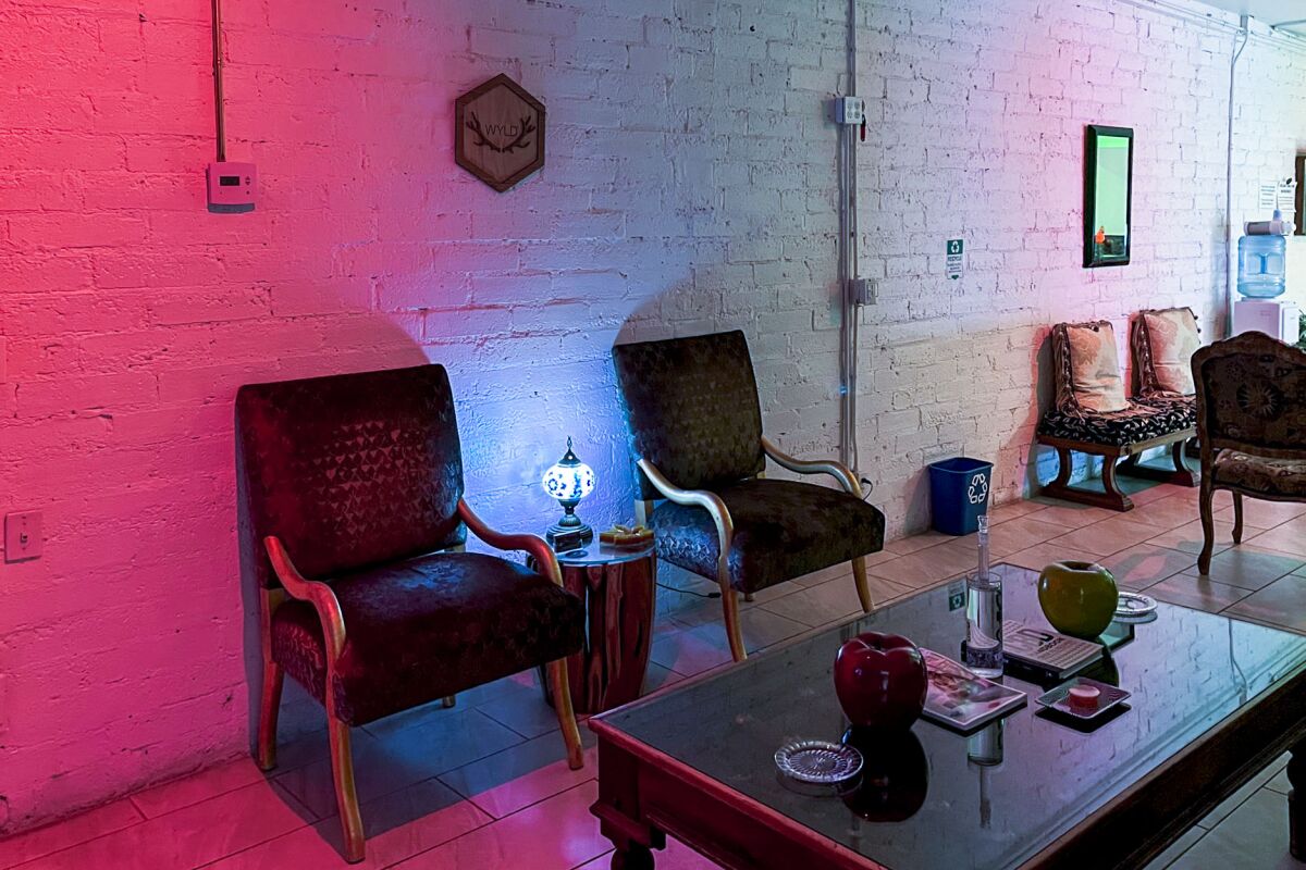 Chairs and a coffee table in a dimly lighted room with white brick walls.
