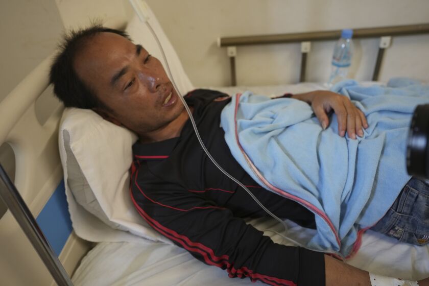 Zhu Pingfan, de 41 años y oriundo de la provincia de Hunan, en China, se recupera en una cama de hospital, el sábado 24 de septiembre de 2022, tras el naufragio de un bote cerca de una isla de Camboya. (AP Foto/Heng Sinith)