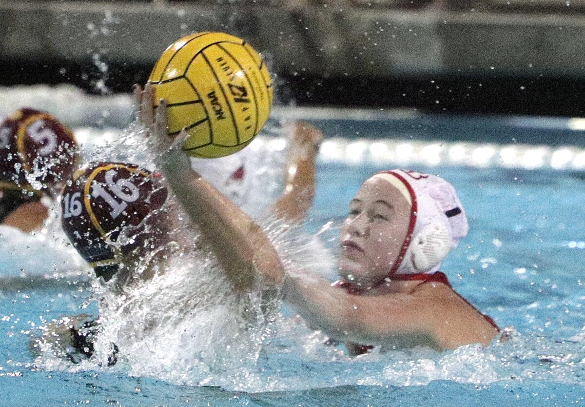 Burroughs High's Nancy Baylor attempts to block a shot taken by Arcadia's Alie Cicero during Thursday's Pacific League Tournament championship game.