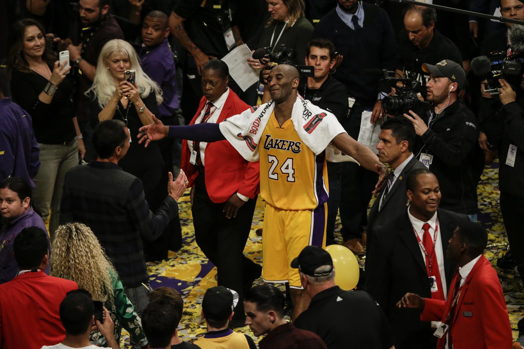 Kobe Bryant moves in to hug his friend and agent Rob Pelinka after playing his last game.