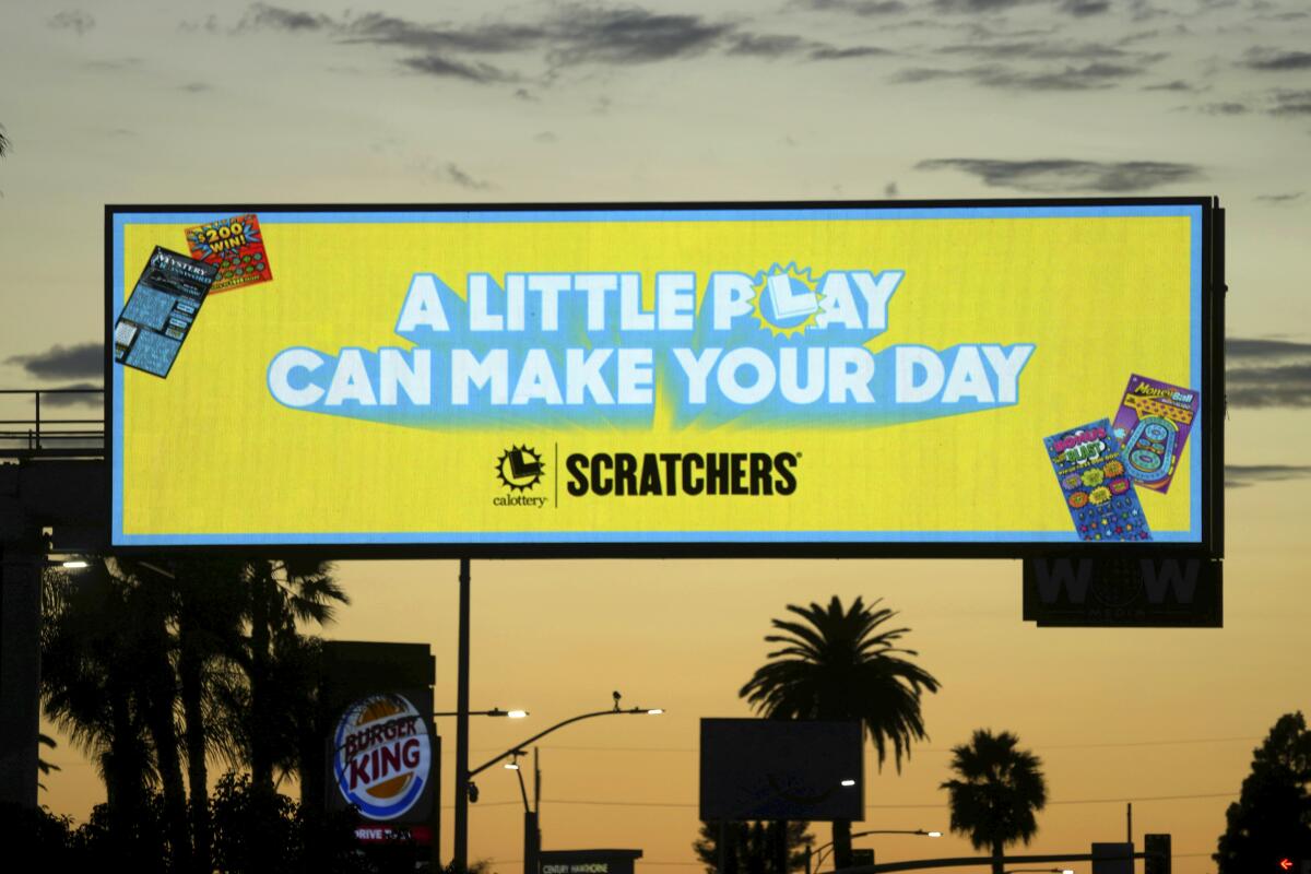 A billboard promoting the California Lottery Scratchers game against a dusk sky 