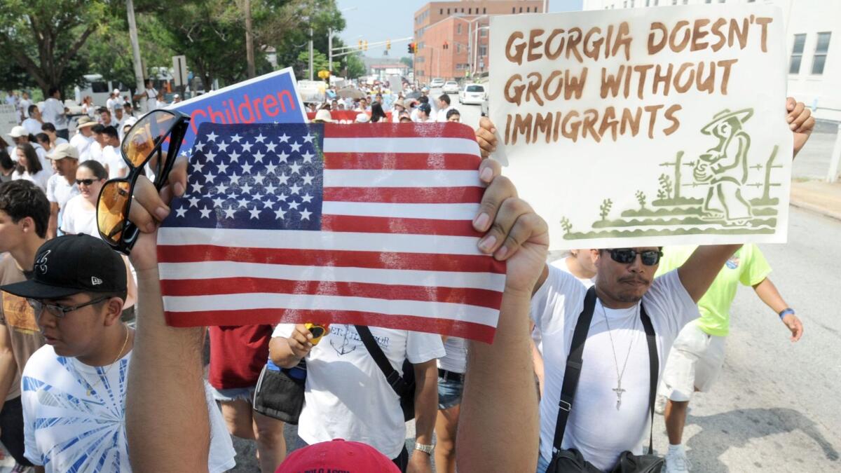 A man holds a United States flag while marching through downtown Atlanta in protest against a Georgia immigration law on July 2, 2011.