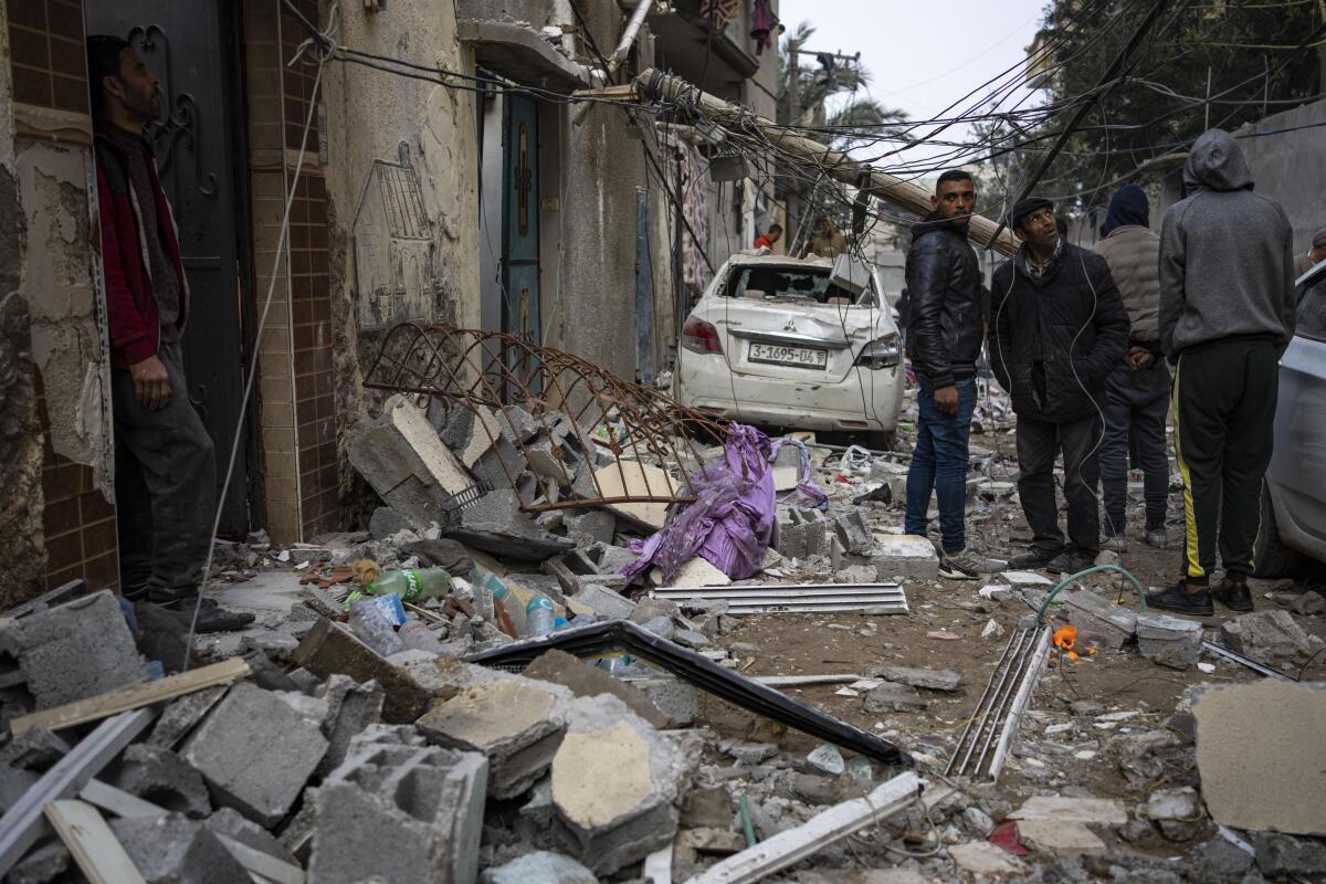 Palestinians look at the destruction after an Israeli airstrike in Rafah, Gaza Strip.