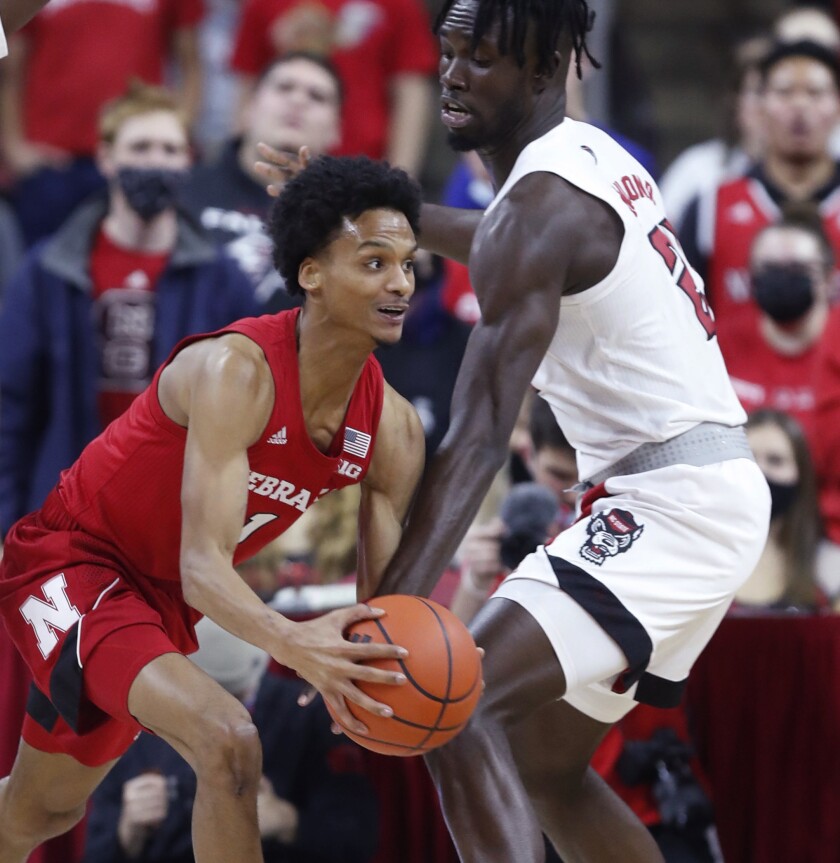Nebraska's Alonzo Verge Jr. (1) gets around the pressure by N.C. State's Ebenezer Dowuona (21) during the first half of an NCAA college basketball game in Raleigh, N.C., Wednesday, Dec. 1, 2021. (Ethan Hyman/The News & Observer via AP)