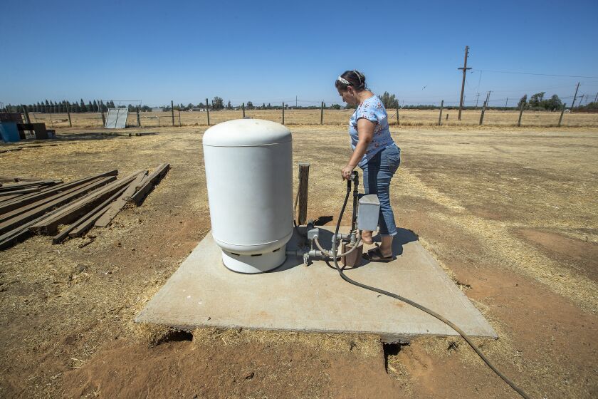 MADERA, CA - AUGUST 05, 2021: Sandra Sevilla, 45, stands next to the well that dried up as a result of the ongoing drought at her family's ranch in an unincorporated area of Madera County. (Mel Melcon / Los Angeles Times)