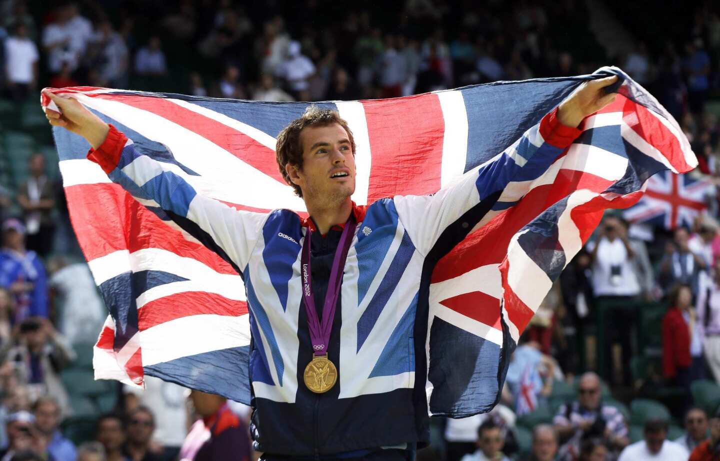 Gold-medalist Andy Murray waves the British flag during the medal ceremony after defeating Roger Federer in the men's tennis singles final on Sunday at the All England Lawn Tennis Club at Wimbledon.