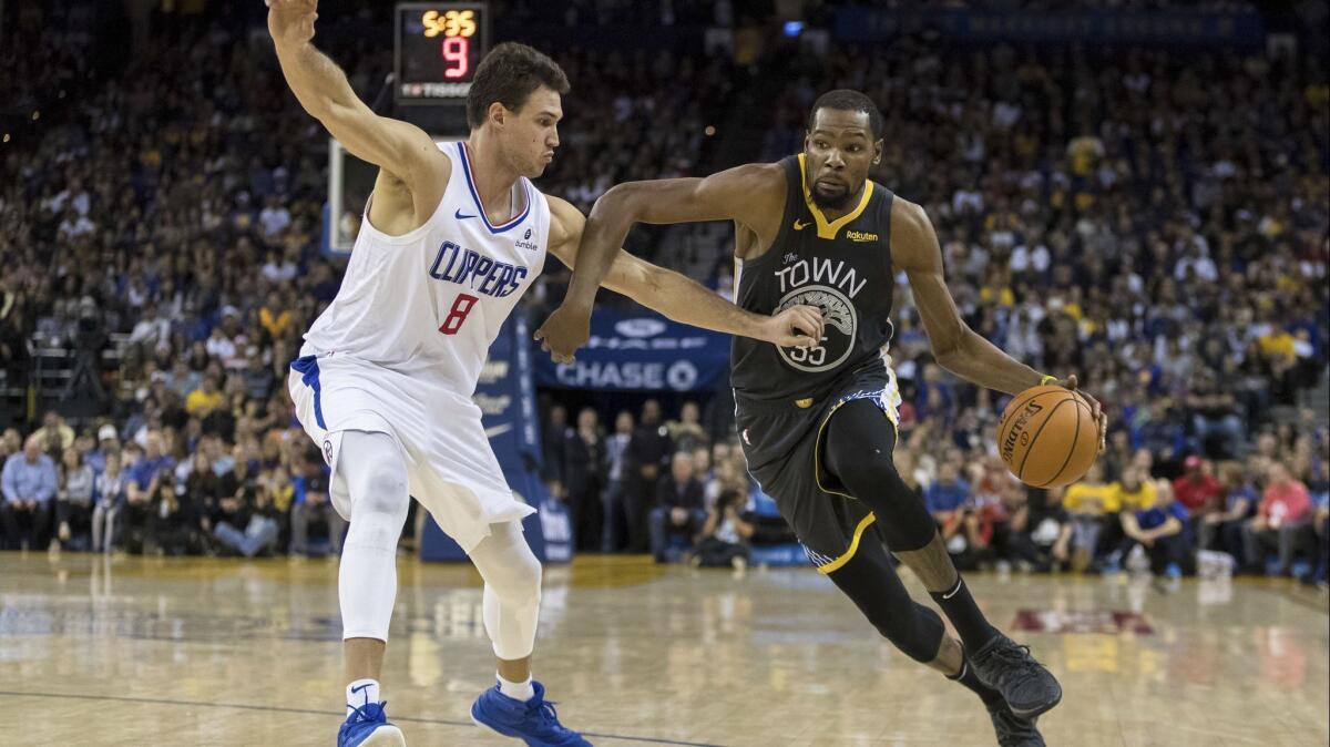 Golden State Warriors forward Kevin Durant (35) dribbles as Clippers forward Danilo Gallinari (8) defends in the fourth quarter on Sunday.