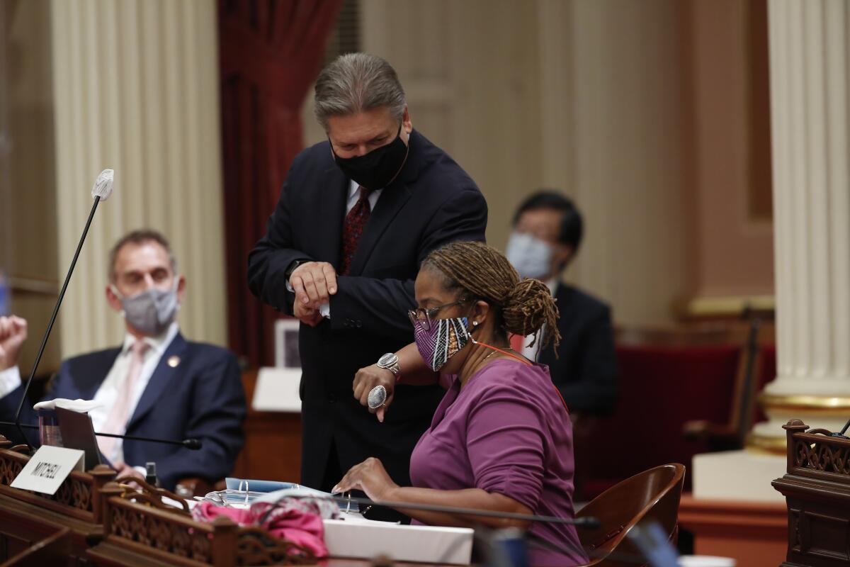 Sen. Holly Mitchell (D-Los Angeles) gets an elbow bump from Sen. Bob Hertzberg (D-Van Nuys).