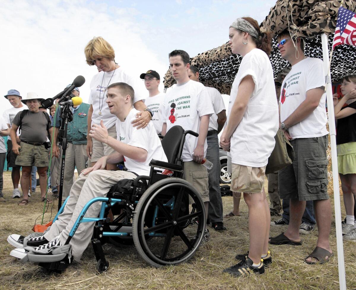 Cindy Sheehan holds her arm around Iraq war veteran Tomas Young in 2005.