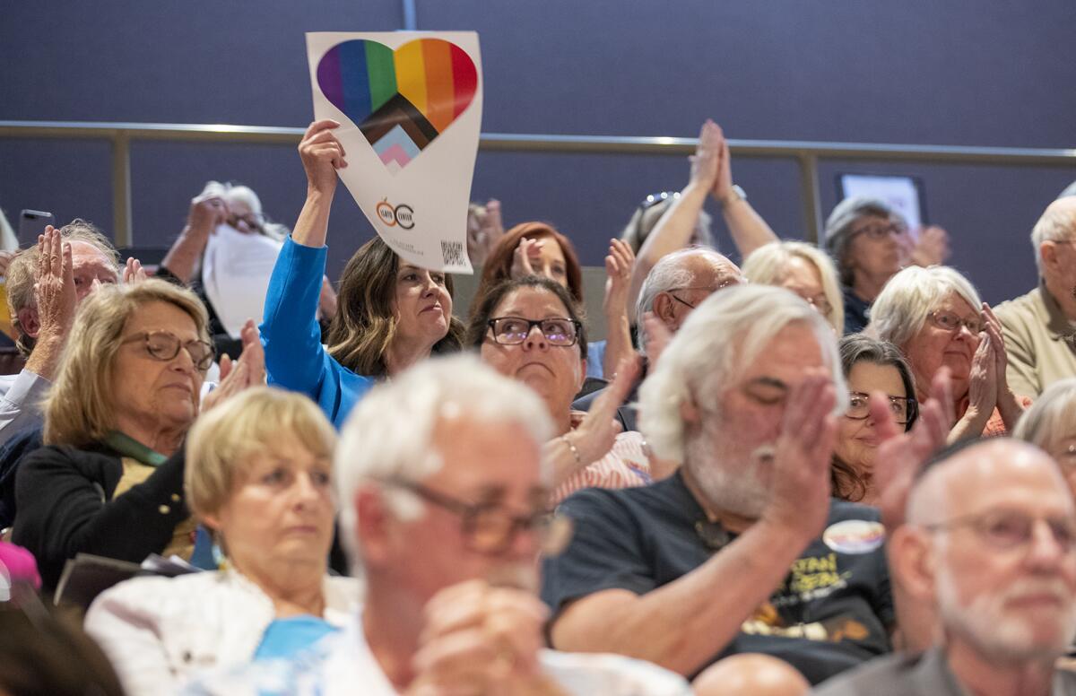 Former Huntington Beach Mayor Kim Carr holds a sign from the LGBTQ Center OC during Tuesday night's City Council meeting.
