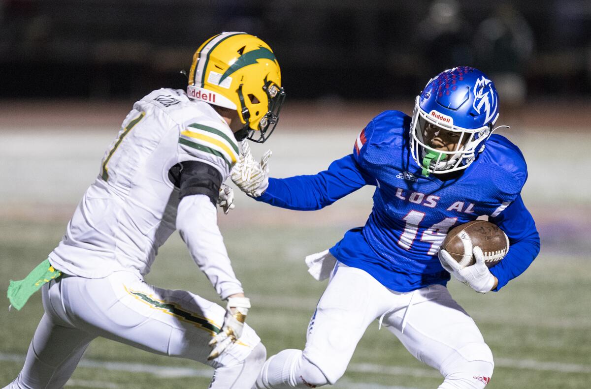 Los Alamitos' Makai Lemon carries the ball under pressure from Edison's Bradley Luna.