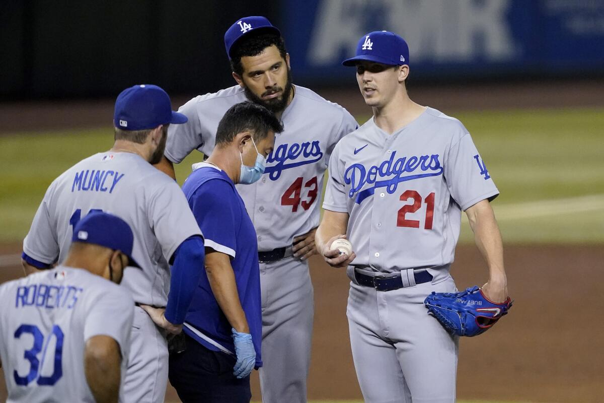 Dodgers pitcher Walker Buehler is checked by a team trainer Sept. 8, 2020, in Phoenix. 