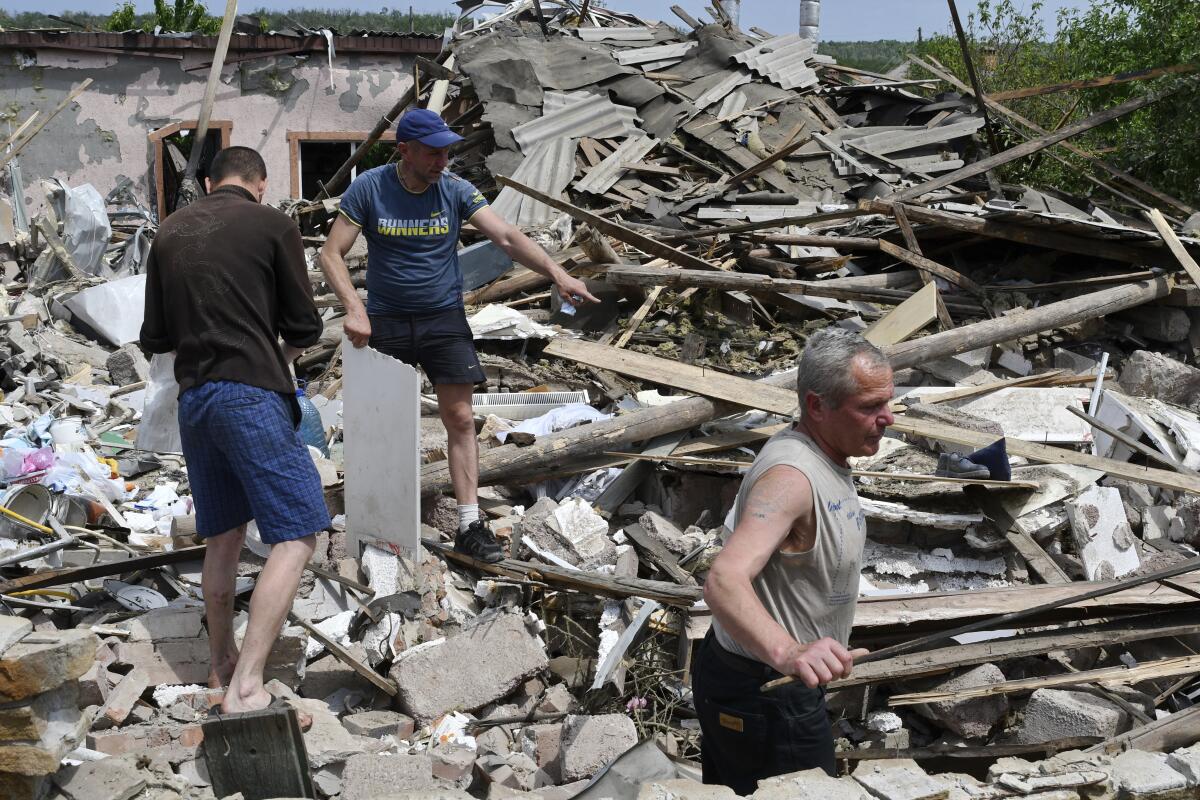 Gente remueve escombros de un edificio destruido por un misil en Sloviansk, Ucrania, 