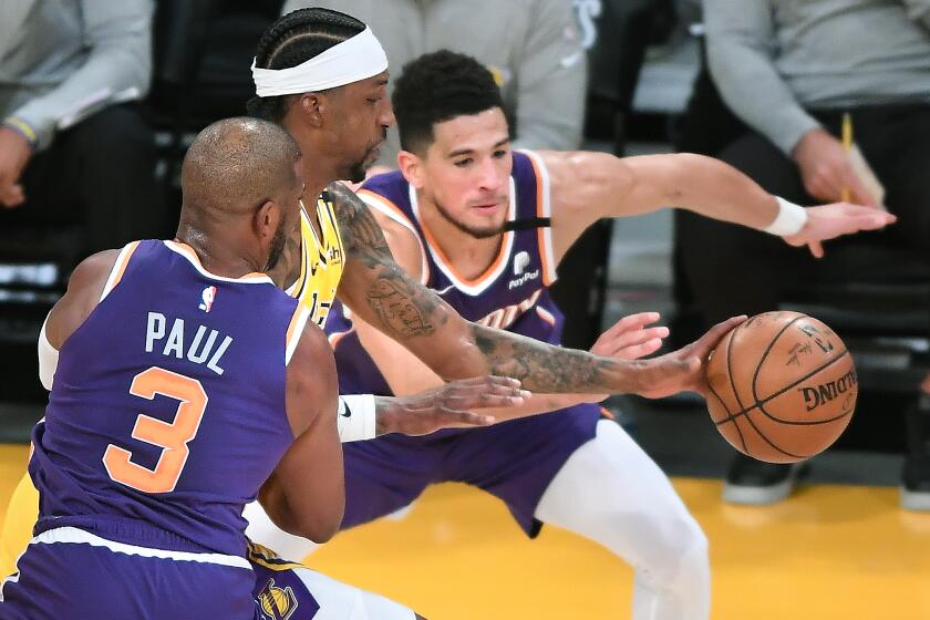 Lkers guard Kentavious Caldwell-Pope steals the ball between Phoenix's Chris Paul and Devin Booker in Game 3 on May 27, 2021.
