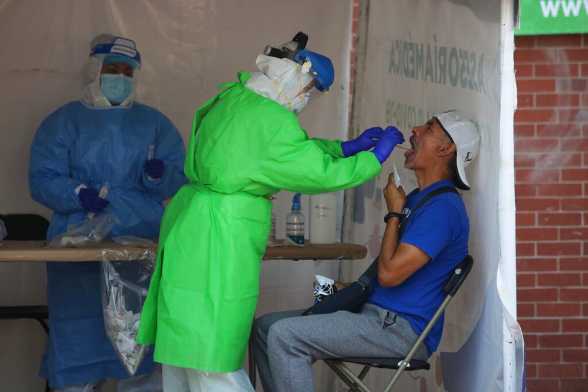 Un trabajador de la salud examina a una persona por el nuevo coronavirus