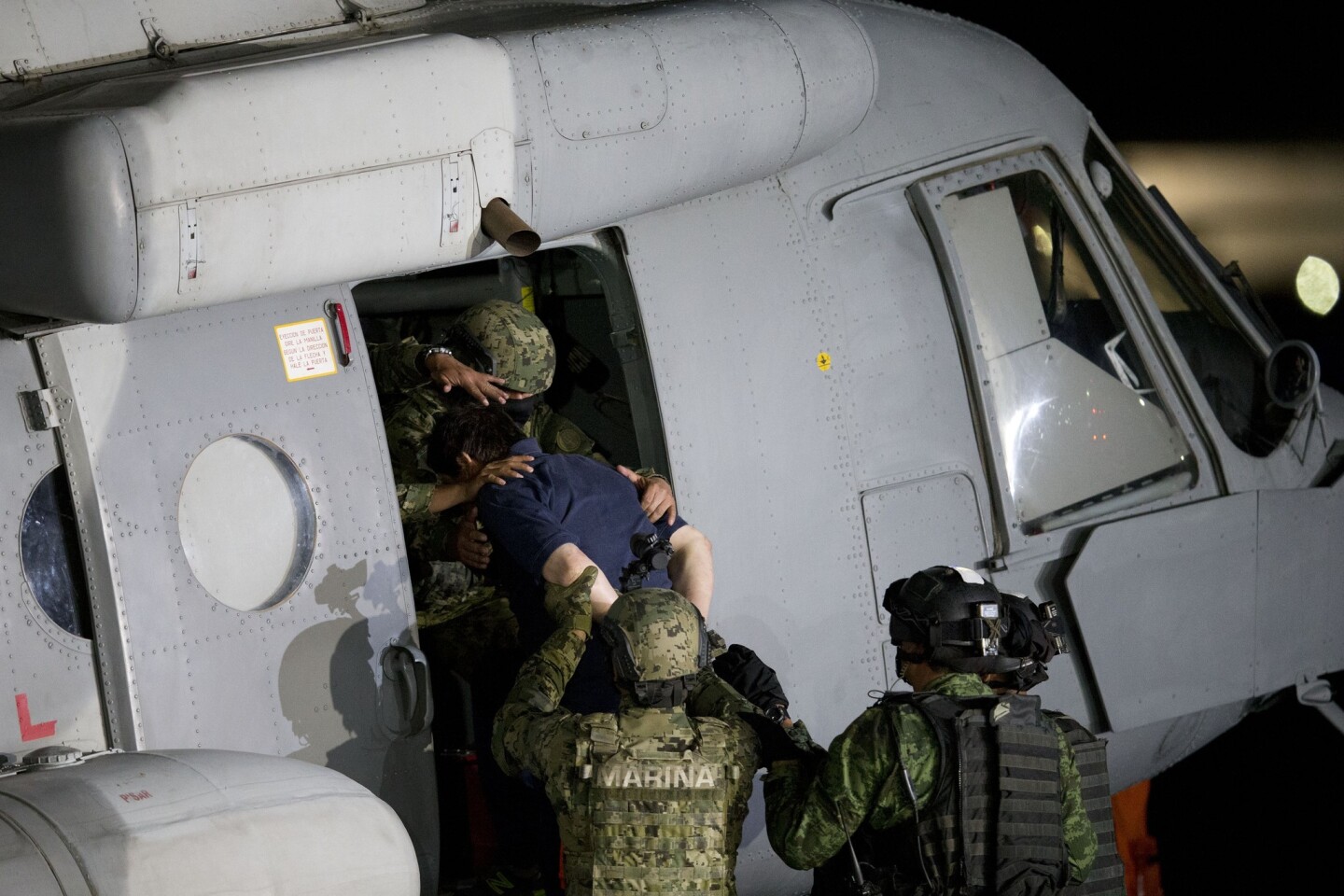 El capo mexicano del narcotráfico Joaquín "El Chapo" Guzmán es subido a un helicóptero de la Marina en un hangar federal en la Ciudad de México, el viernes 8 de enero de 2016.