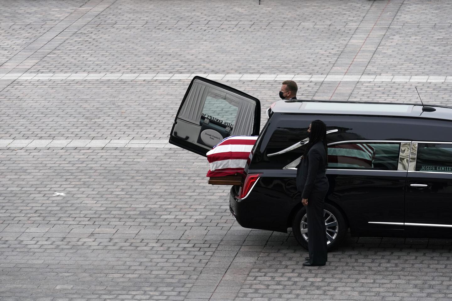 The casket of Justice Ruth Bader Ginsburg is prepared for transfer from the hearse that carried it to the U.S. Capitol
