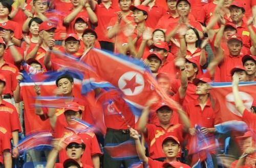 North Korean fans cheer for their team before the start of the women's first round Group F soccer match against Germany.