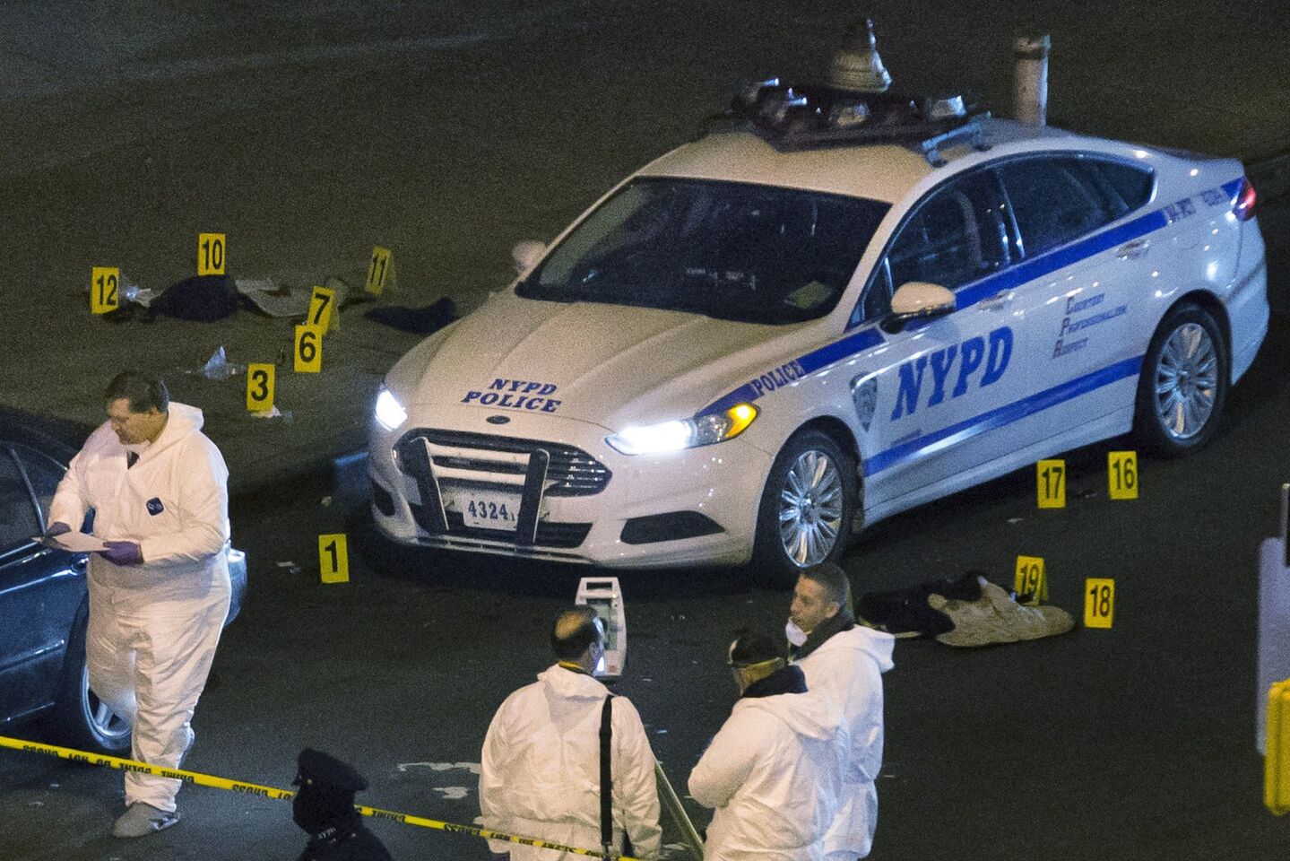 Bulletproof vests lie beside an NYPD patrol car as investigators work at the scene of two officers' fatal shootings. Authorities say the gunman acted so quickly that neither officer had time to draw his weapon.