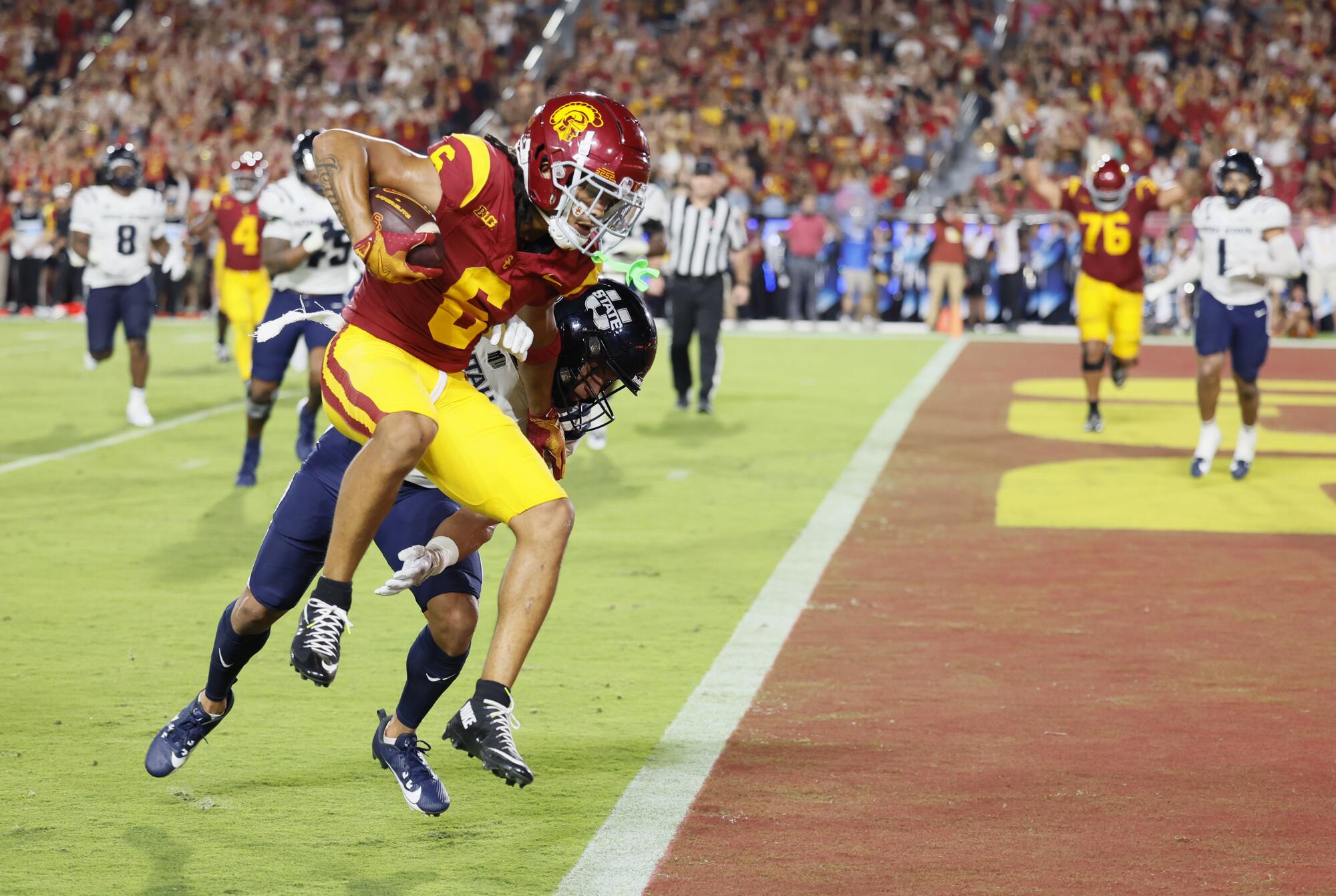 USC geniş alıcısı Makai Lemon, Utah Eyaleti'nin güçlü güvenliği Jordan Vincent'ı savuştururken touchdown'ı tamamladı