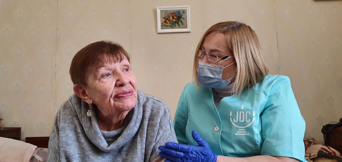Natalia Berezhnaya, left, is seen in Odessa, Ukraine, in this undated photo with her home care worker as one of approximately 5,200 Holocaust survivors in Ukraine who receives ongoing home care funded by the Claims Conference and implemented by the Jewish Joint Distribution Committee (JDC) and Hesed Social Service network. The organization that handles claims on behalf of Jews who suffered under the Nazis says that Germany has agreed to extend funding by another $720 million that will be distributed to more than 300 social welfare organizations globally to provide help for Holocaust survivors. (Alexander Vdovichenko/The Jewish Joint Distribution Committee via AP)