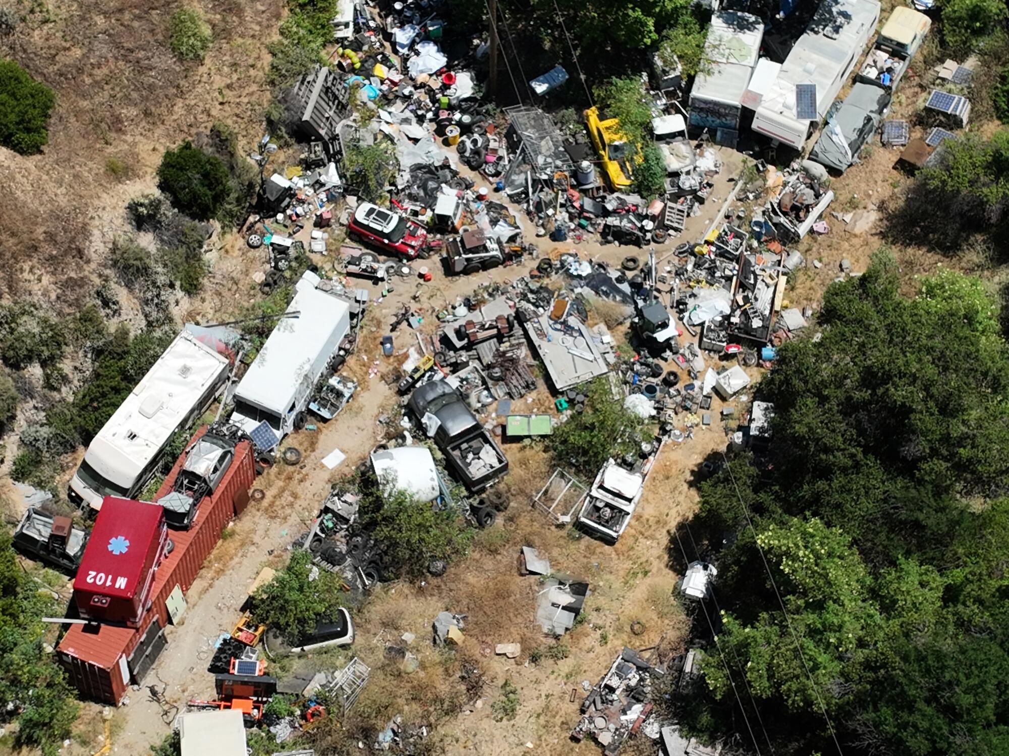An aerial view of a property littered with objects and vehicles.