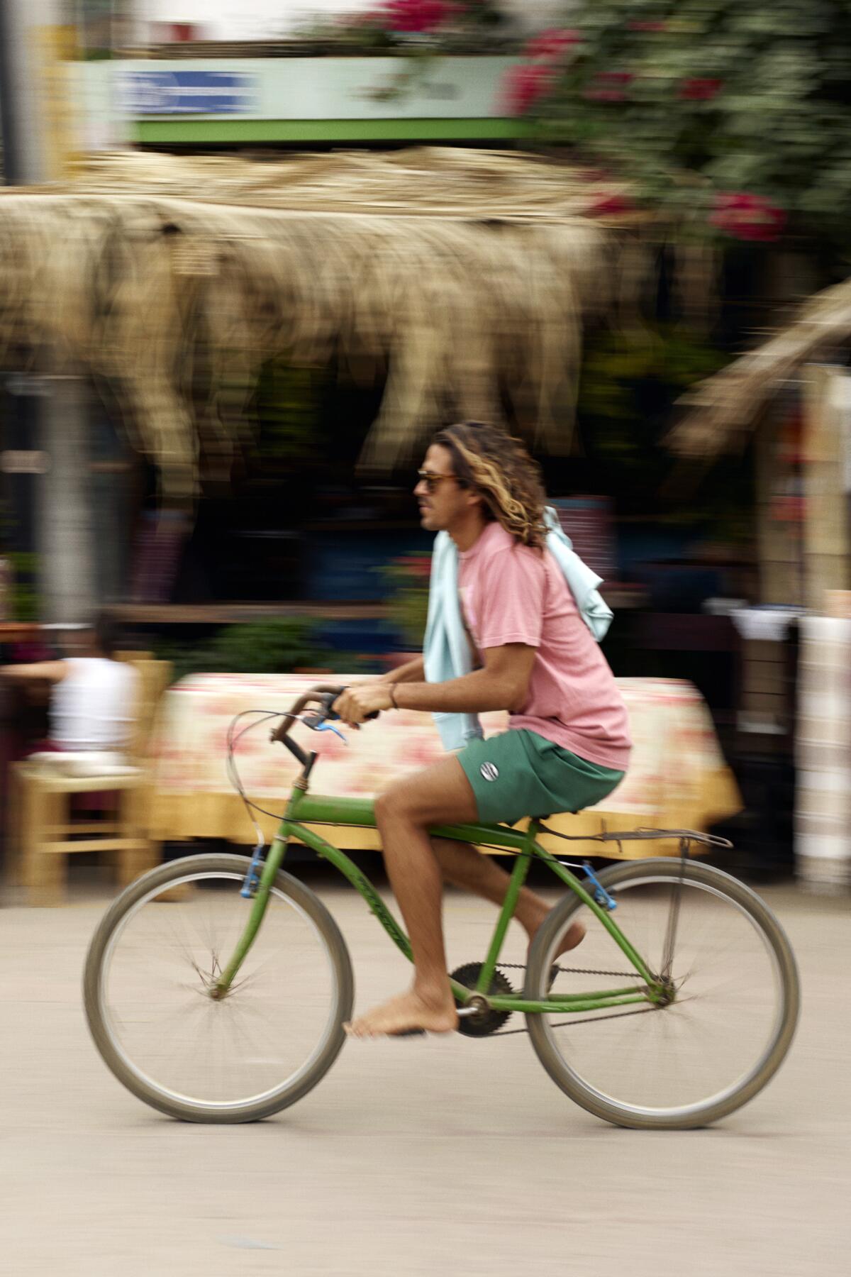 A bike rider clad in clothes from Mr Porter's Gone Surfin' capsule collection