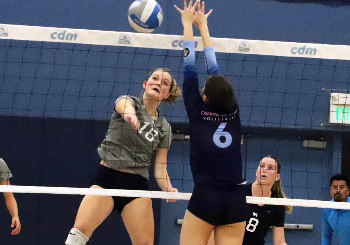 Newport Harbor's Sadie Henderson (18) spikes the ball past CdM's Katie Rinker (6) in the Battle of the Bay on Thursday.