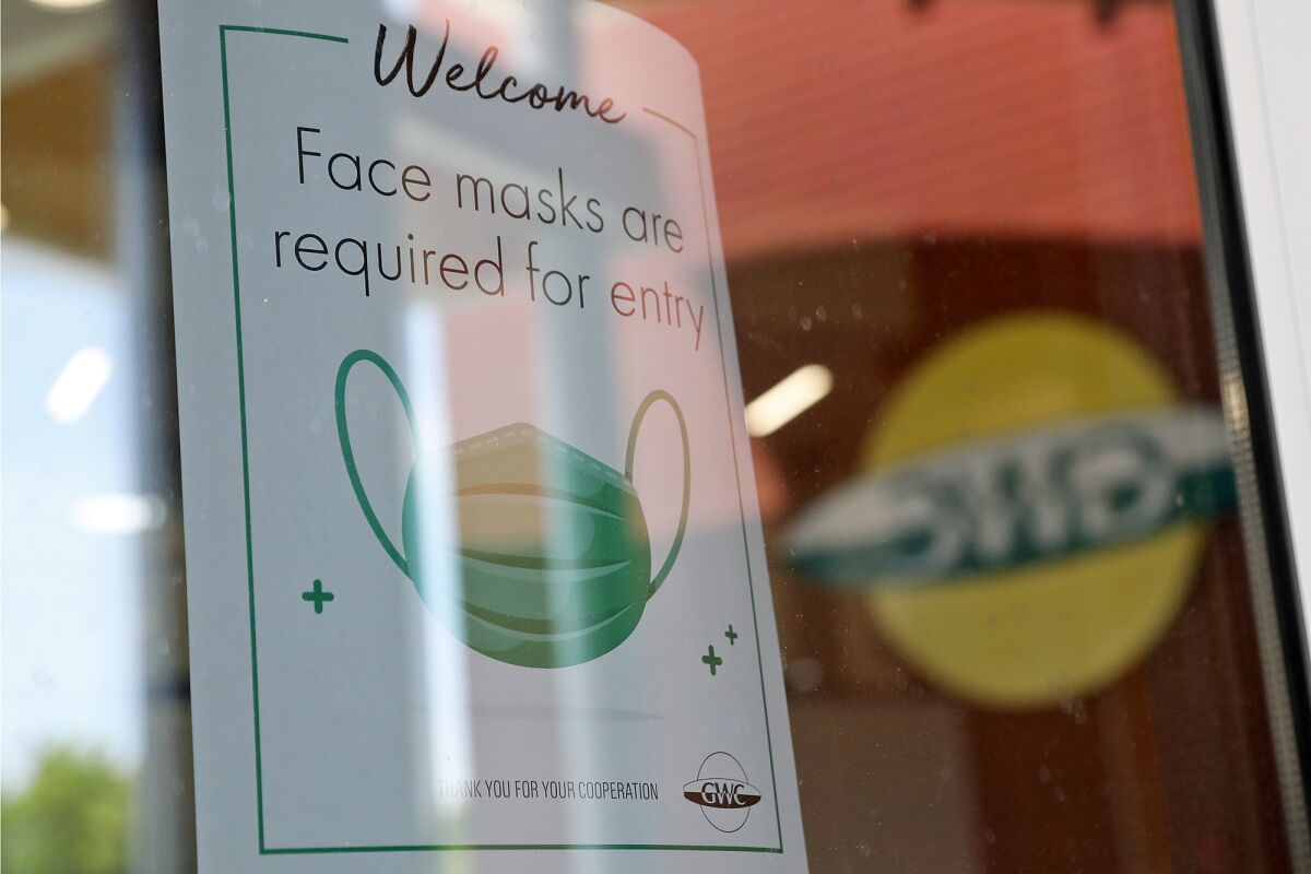 A sign at Huntington Beach's Golden West College reminds students, faculty and staff masks are required for entry.