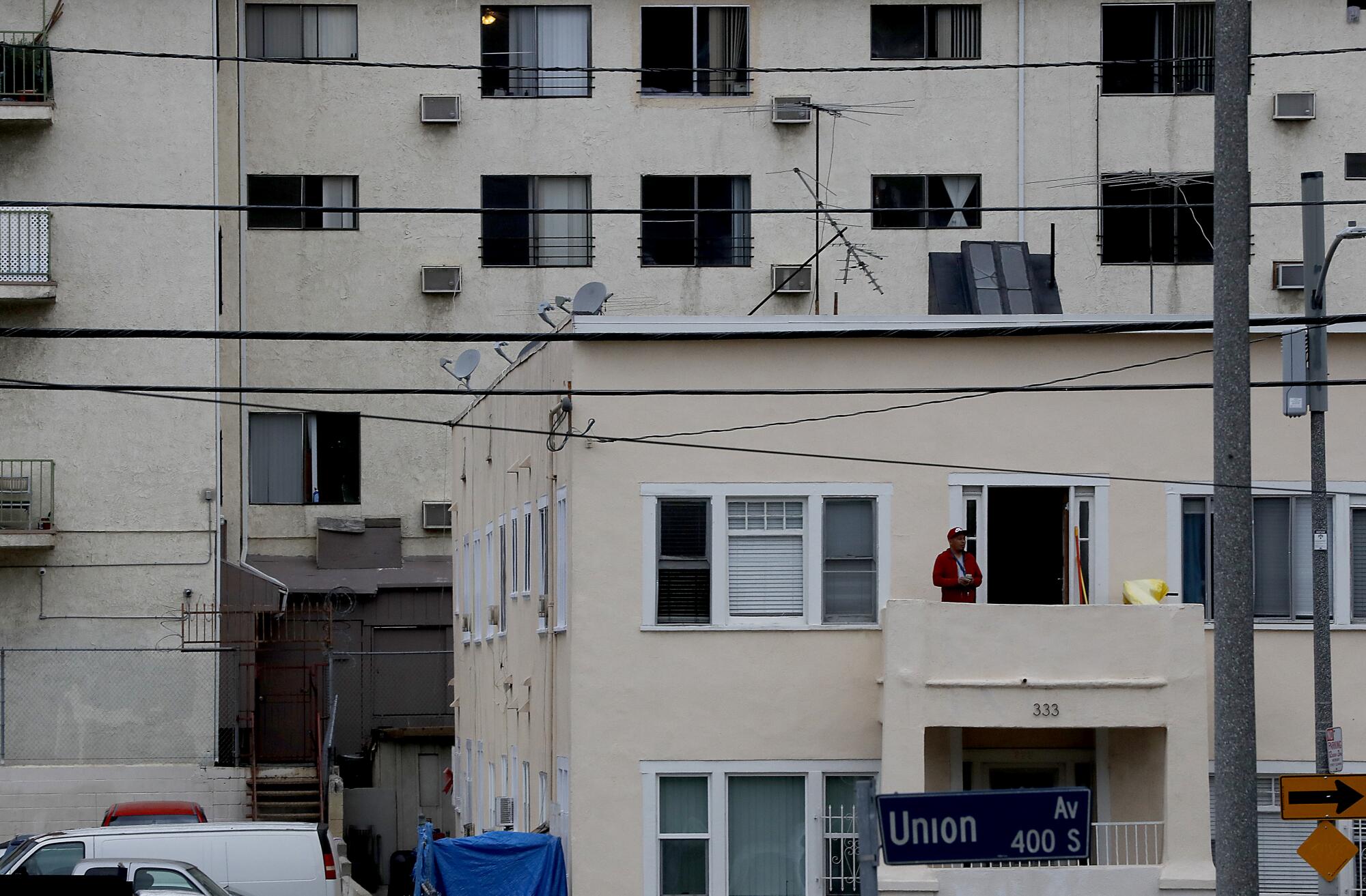 A man stands on a balcony of an apartment building on Union Avenue in the Westlake area of Los Angeles.