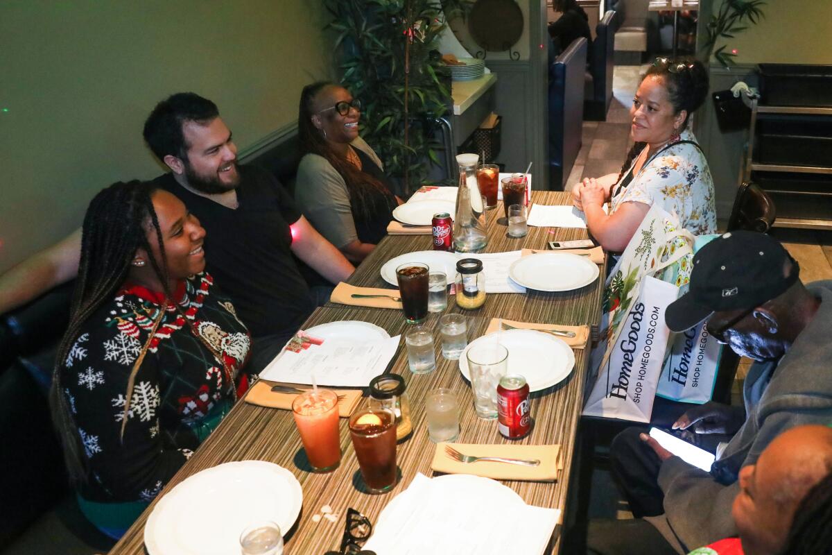 Six people sit around a rectangular restaurant table.