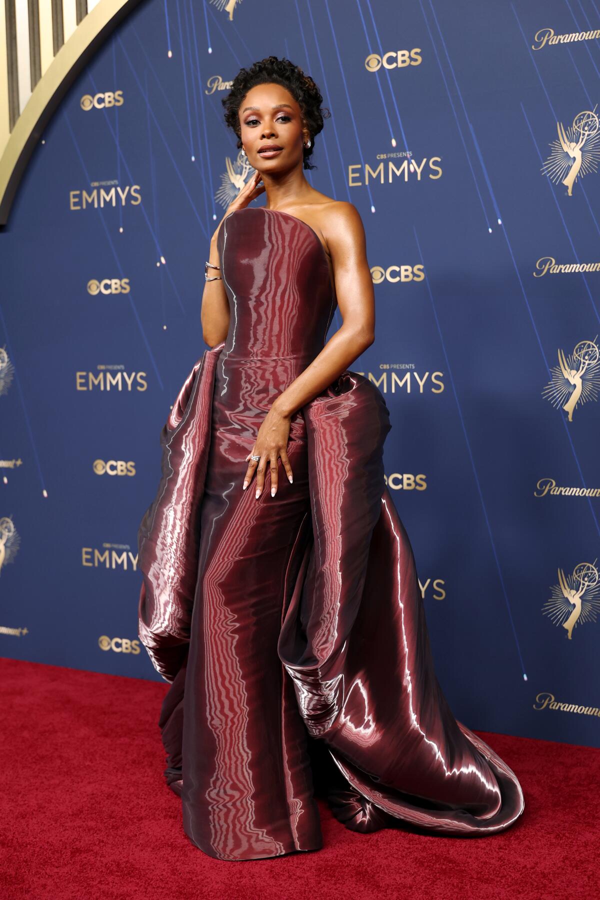 Zuri Hall wears a metallic burgundy dress.