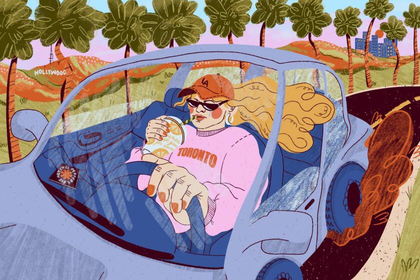 A woman drinks lemonade as she drives through Los Angeles.