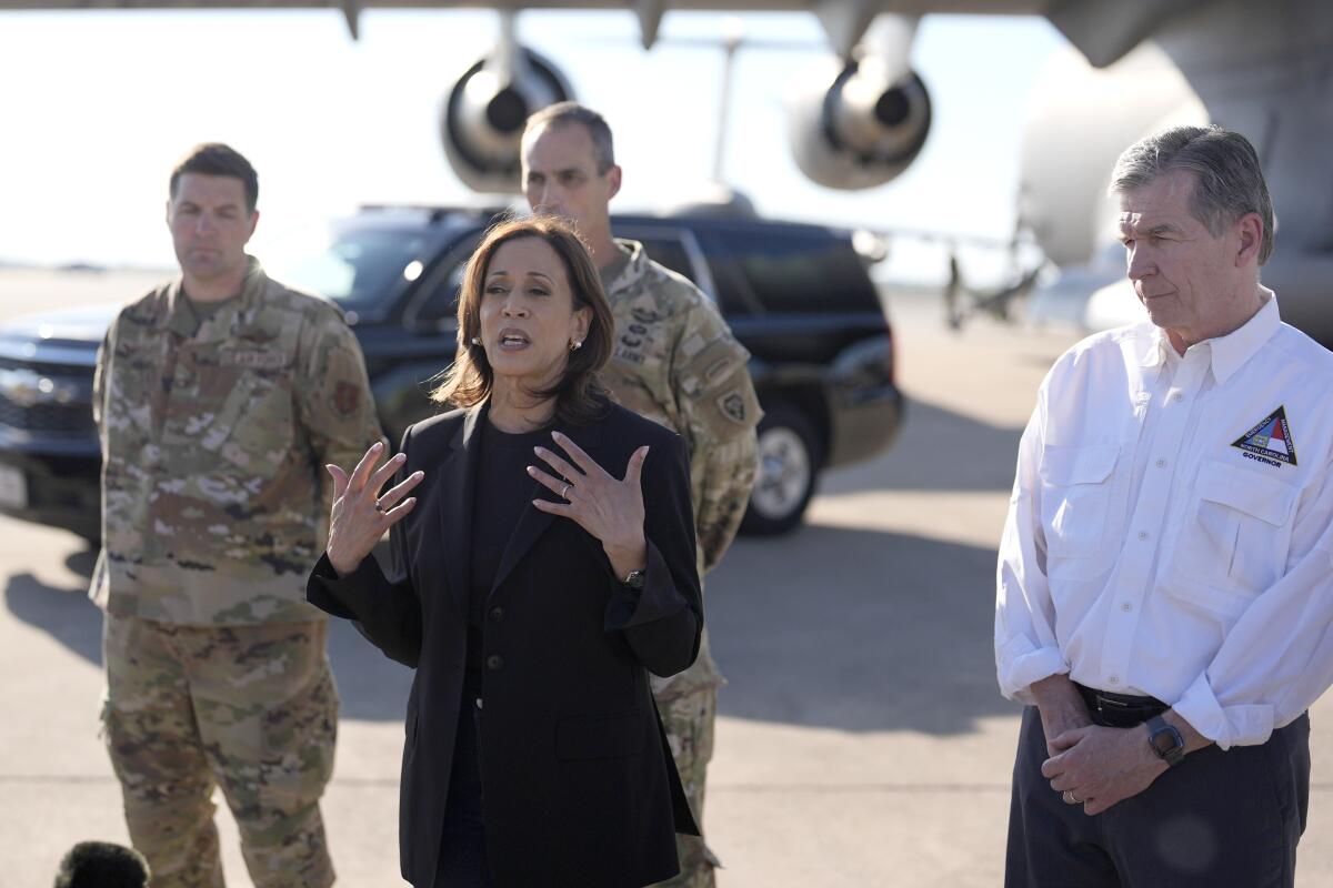 Vice President Kamala Harris speaks on a tarmac with a plane in the background.