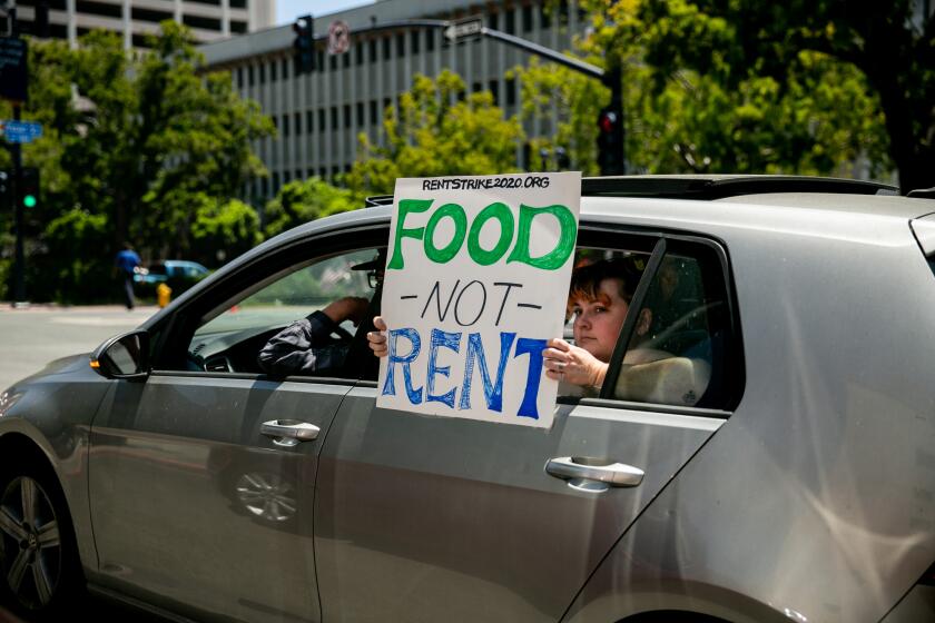 Protesters pass through downtown San Diego demonstrating from their cars as part of a "Food Not Rent" caravan on May 1, 2020 in San Diego, California.