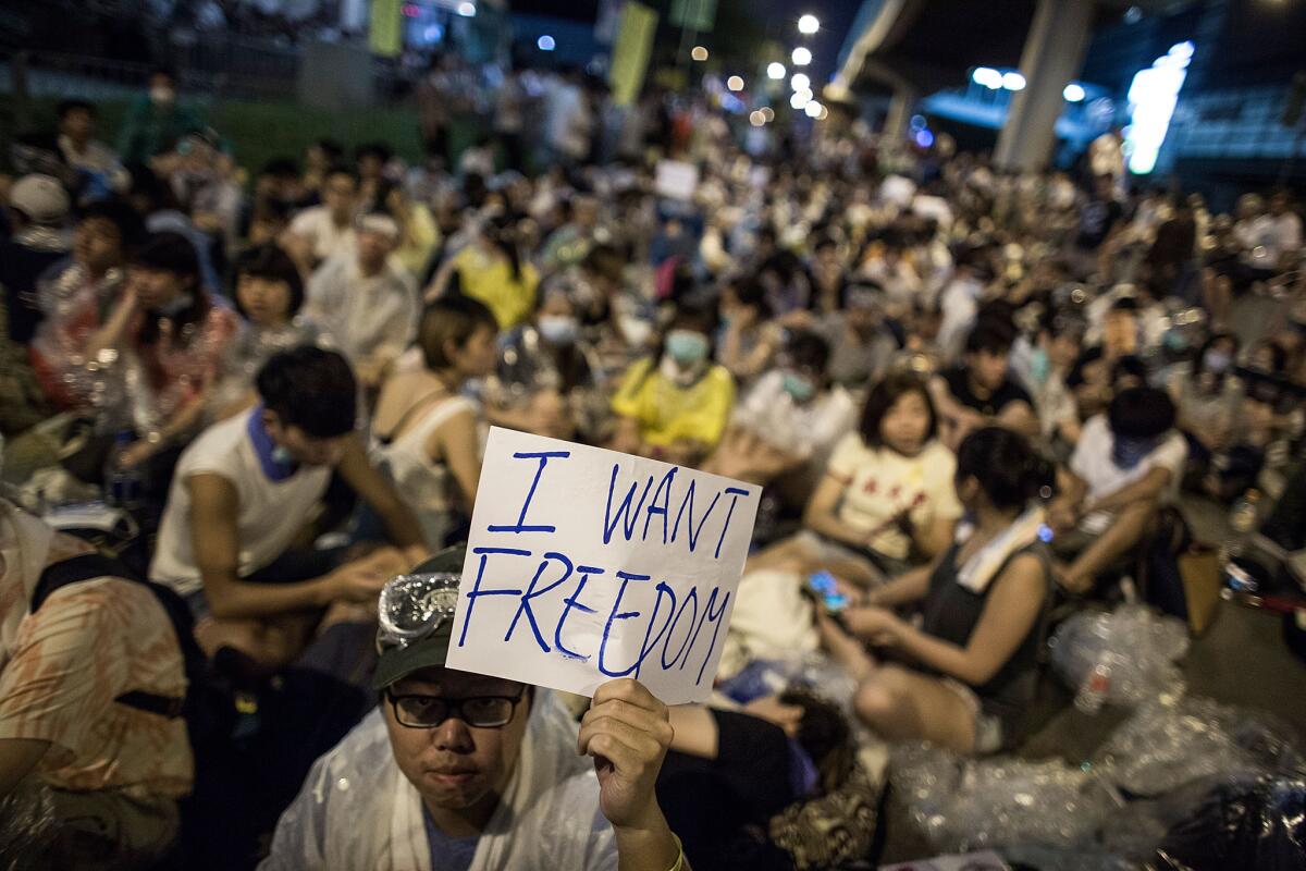 A protester holds a sign during a pro-democracy rally in a plaza at Hong Kong's main government compound Saturday.